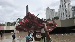 Petugas Pusat Pengelolaan Kompleks (PPK) Kemayoran membersihkan sampah yang muncul akibat banjir di Underpass Kemayoran, Jakarta, Minggu (2/2/2020). Selain melumpuhkan akses, banjir setinggi hingga 5 meter tersebut menyebabkan sampah memenuhi Underpass Kemayoran. (merdeka.com/Iqbal S. Nugroho)