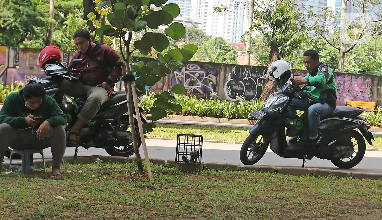 Pengemudi ojek online lagi bersantai di kasawan Prof. Dr. Satrio, Jakarta, Selasa (2/03/2021). Data 21 Februari 2021, DKI Jakarta berhasil keluar dari zona merah Covid-19 yang dilaporkan Satuan Tugas Penanganan Covid-19 melalui covid19.go.id, pada Selasa (2/3/2021). (Liputan6.com/Herman Zakharia)