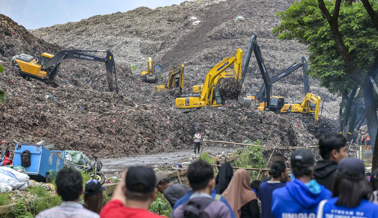 Insiden yang terjadi pada Minggu 8 Maret 2026, mengakibatkan setidaknya lima orang meninggal dunia tertimbun material longsoran di lokasi kejadian. Tampak dalam foto, tim penyelamat menggunakan alat berat untuk mencari korban longsor di Tempat Pembuangan Sampah Terpadu (TPST) Bantargebang, Bekasi, Jawa Barat, pada 9 Maret 2026. (BAY ISMOYO/AFP)