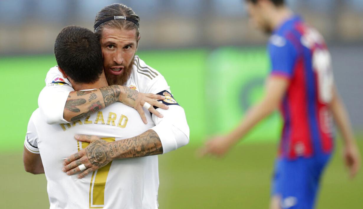 Bek Real Madrid, Sergio Ramos, melakukan selebrasi bersama Eden Hazard usai membobol gawang Eibar pada laga La Liga di Estadio Alfredo Di Stefano, Senin (15/6/2020). Real Madrid menang 3-1 atas Eibar. (AP/Bernat Armangue)