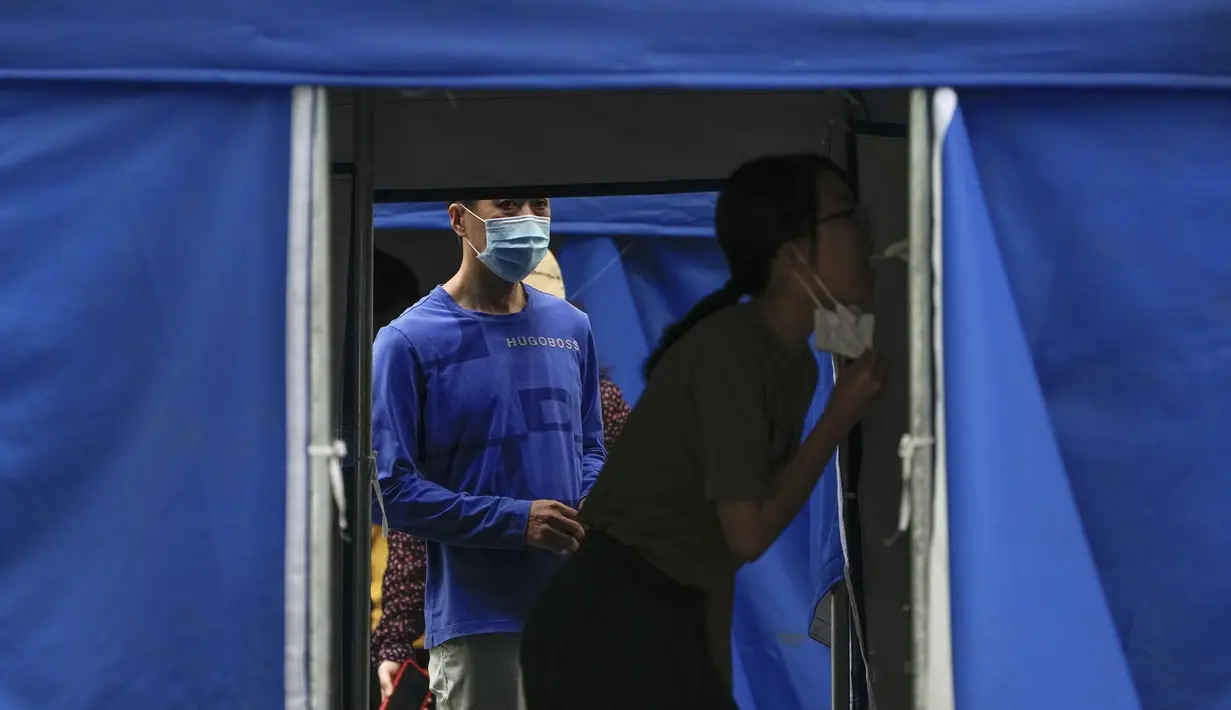 <p>Warga mengantre untuk tes usap tenggorokan di fasilitas pengujian virus corona di Beijing, Senin (13/6/2022). Pengujian massal COVID-19 akan berlangsung antara Senin hingga Rabu di distrik Chaoyang, tempat bar itu berada, menurut para pejabat dalam konferensi pers. (AP Photo/Andy Wong)</p>