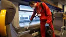 Seorang pekerja membersihkan gerbong kereta regional di stasiun kereta Garibaldi di Milan, Jumat (28/2/2020). Otoritas Italia mengambil langkah-langkah pencegahan penyebaran virus corona dengan menyemprot disinfektan dan membersihkan kereta serta transportasi umum. (AP/Luca Bruno)