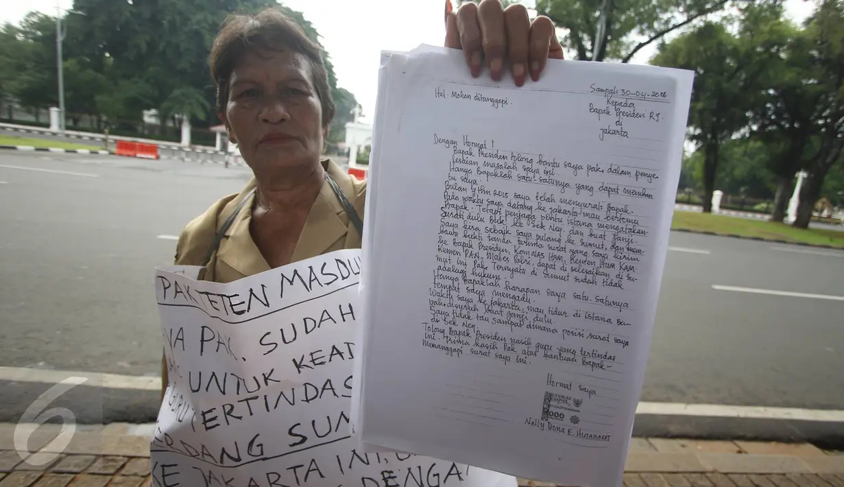 Nelly Hutabarat, guru asal Deli Serdang, menunjukkan surat untuk Presiden Jokowi di depan Istana Negara, Jakarta, Rabu (13/7). Nelly menuntut keadilan atas penutupan SDN 10-61-59 dan pembongkaran rumah dinasnya 2011 silam. (Liputan6.com/Immanuel Antonius)