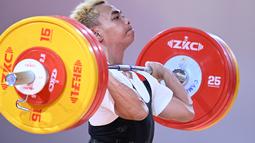 Lifter asal Lampung ini berhasil meraih medali emas dengan total angkatan 303 kilogram, dan berhasil memecahkan rekor di clean and jerk dengan angkatan 170 kilogram. (AFP/Mohd Rasfan)