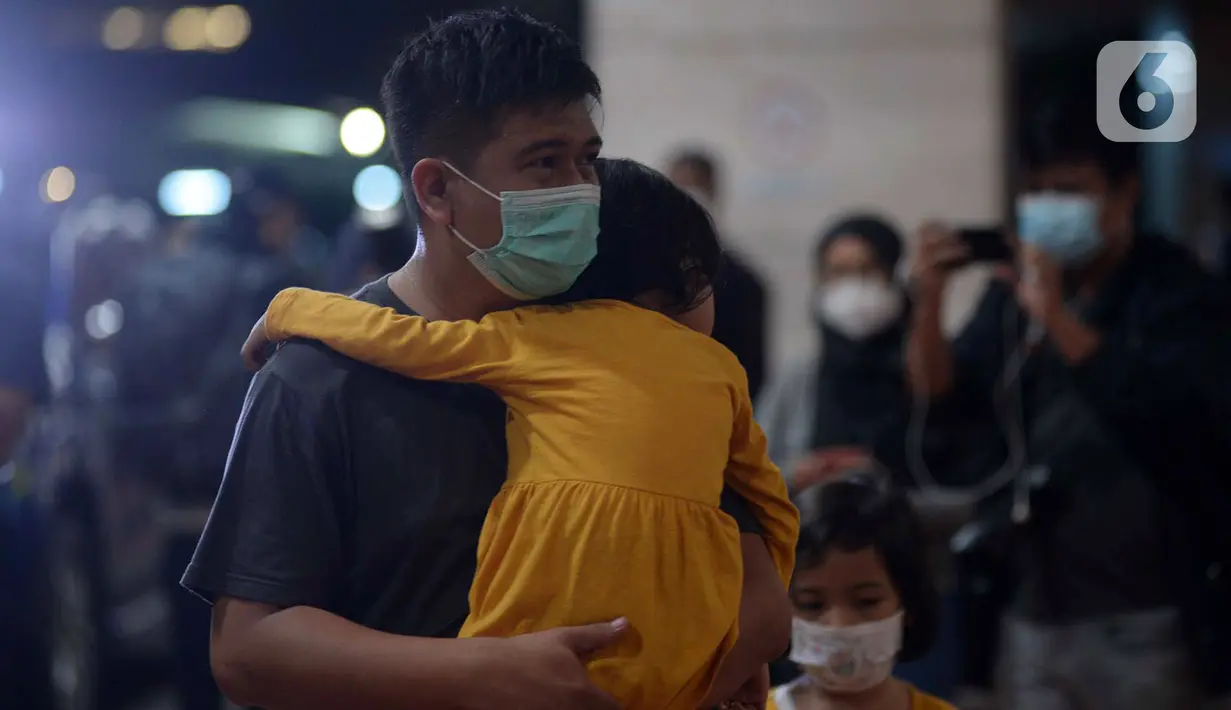 Ekspresi seorang pria yang menggendong anak kecil saat berada di Posko Crisis Center Sriwijaya Air SJ 182, Bandara Soekarno-Hatta, Tangerang, Banten, Sabtu (9/1/2021). Keluarga korban masih menunggu kabar terkait hilang kontaknya pesawat Sriwijaya Air SJ 182. (merdeka.com/Imam Buhori)