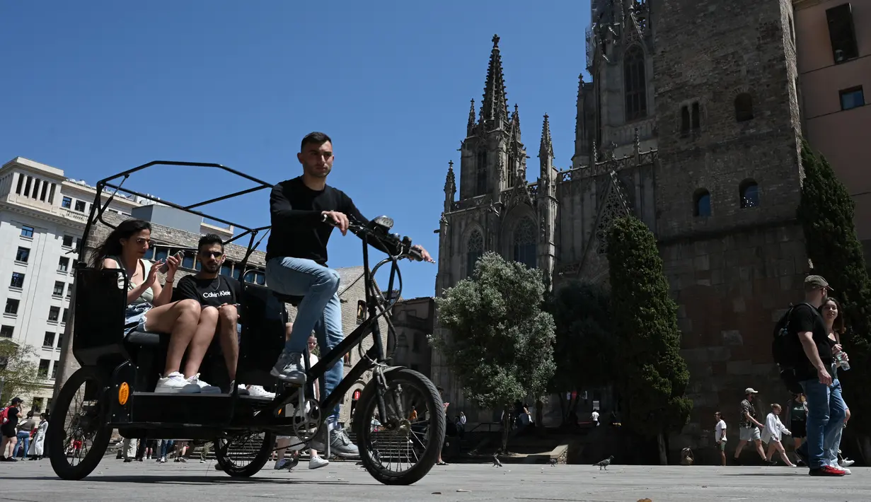 <p>Turis menikmati perjalanan dengan ojek di Plaza de la Catedral di Barcelona, ​​​​pada 11 Mei 2022. Pengunjung sekali lagi memadati jalan-jalan sempit di kawasan Gothic Barcelona yang sempit saat perjalanan global bangkit kembali dari pandemi COVID-19, menghidupkan kembali kekhawatiran atas pariwisata massal di kota pelabuhan Spanyol. (LLUIS GEN / AFP)</p>