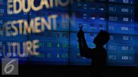 Pengunjung melintas di dekat monitor perkembangan saham di Bursa Efek Indonesia, Jakarta, Senin (2/11).  Indeks Harga Saham Gabungan (IHSG) di Bursa Efek Indonesia (BEI) pada Senin dibuka melemah sebesar 12,76 poin. (Liputan6.com/Immanuel Antonius)