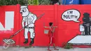 Warga melintasi mural bernuansa politik di Penjaringan, Jakarta, Minggu (7/8). Pesan-pesan yang disampaikan oleh mural politik ini biasanya bercermin dari kegiatan politik di Indonesia saat ini. (Liputan6.com/Angga Yuniar)