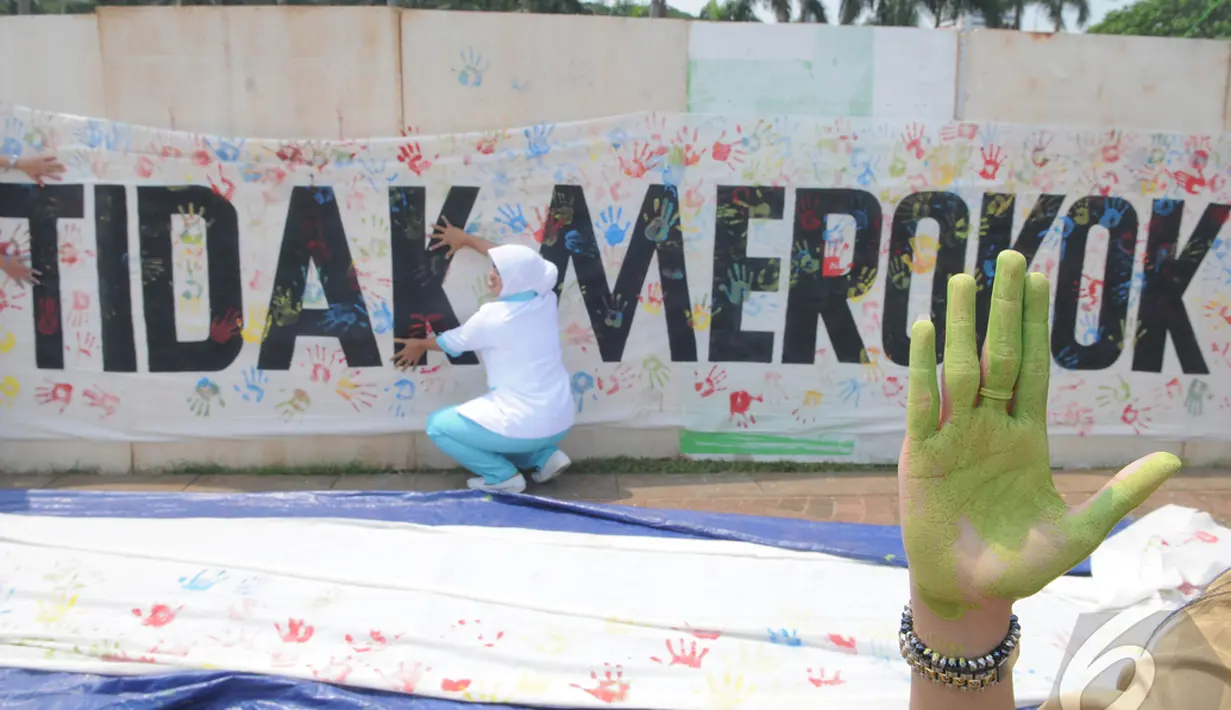 Peserta menunjukan cap telapak tangan ketika peringatan hari Kesehatan Nasional (HKN) ke-50 di kawasan silang Monas. Cap telapak tangan tersebut merupakan dukungan kampanye Komitmen Tidak Merokok, Jakarta, Rabu (12/11/14) (Liputan6.com/Herman Zakharia)