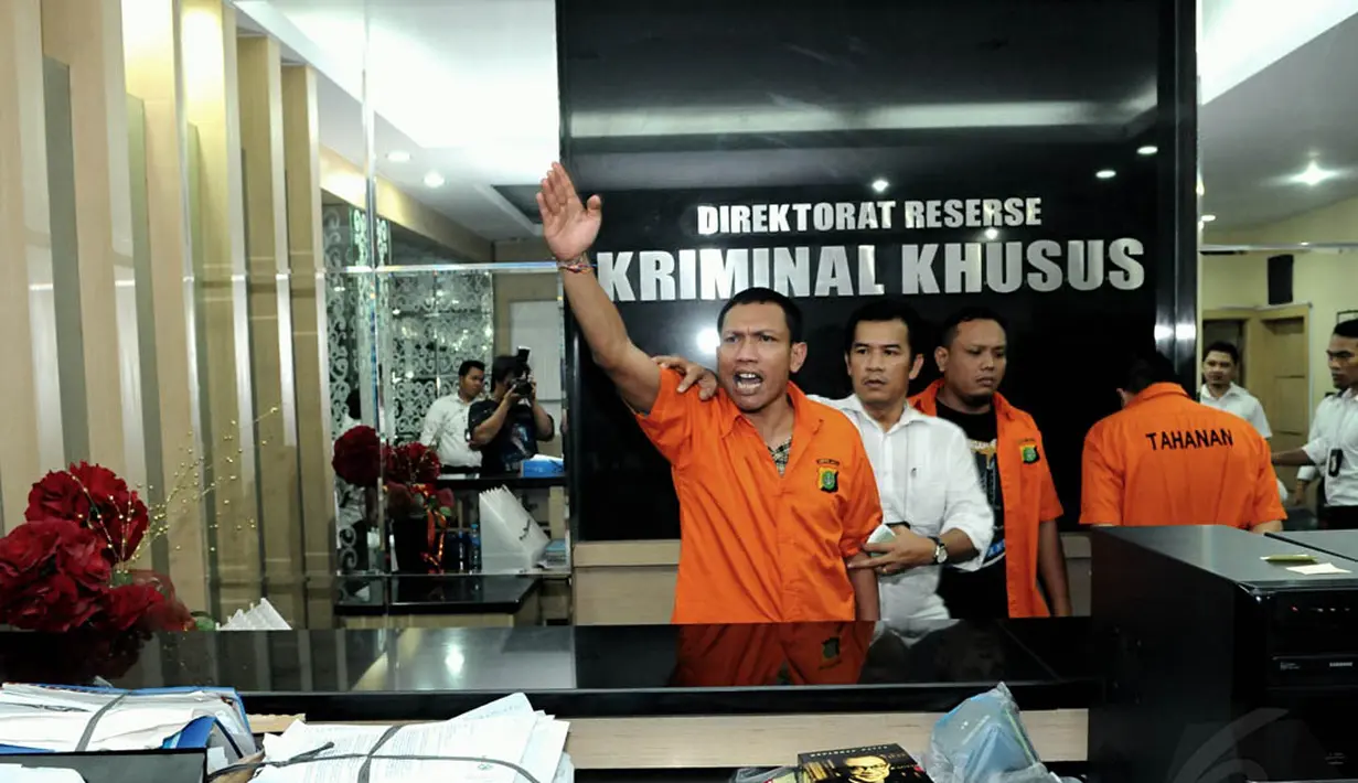 Admin twitter @TrioMacan2000, Raden Nuh dan Edi Saputra, berteriak-teriak sambil mengangkat tangan kanan saat digelar rilis di Mapolda Metro Jaya, Jakarta, Senin (3/11/2014). (Liputan6.com/Andrian M Tunay)