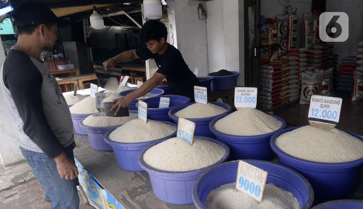 Pedagang beras melayani pembeli di pinggir Jalan Raya Pamulang, Tangerang Selatan, Banten, Jumat (11/12/2020). Jelang Natal dan Tahun Baru 2021, harga beras dipasaran masih normal tidak ada kenaikan. (merdeka.com/Dwi Narwoko)