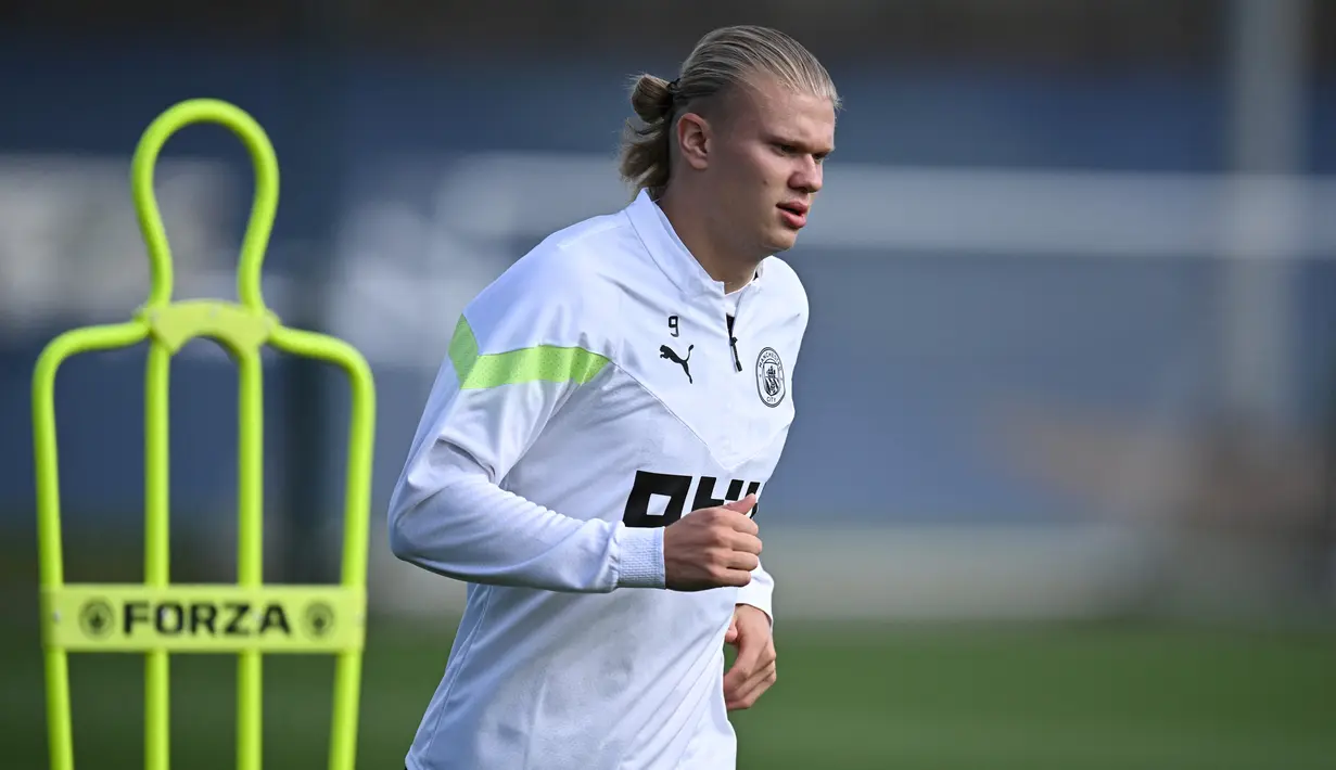 Striker Manchester City, Erling Haaland melakukan pemanasan dalam sesi latihan di City Football Academy, di Manchester, Inggris (5/9/2022). Manchester City akan bertanding melawan Sevilla pada Grup G Liga Champions di Estadio R. Sanchez Pizjuan. (AFP/Oli Scarff)