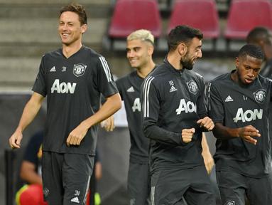 Pemain Manchester United, Bruno Fernandes bercanda dengan Aaron Wan-Bissaka saat sesi latihan jelang laga Liga Europa di Stadion Rhein Energie, Cologne, Minggu (9/8/2020). Manchester United akan berhadapan dengan Copenhagen. (AFP/Sascha Steinbach)