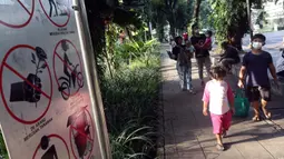 Anak-anak bersiap masuk ke ruang terbuka hijau Taman Suropati, Jakarta, Sabtu (23/10/2021). Selama berada di ruang terbuka hijau, pengunjung diwajibkan mematuhi protokol kesehatan, seperti mencuci tangan, mengenakan masker dan menghindari kerumunan. (Liputan6.com/Helmi Fithriansyah)