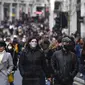 Orang-orang berjalan dengan mengenakan masker dan membawa tas belanjaan di Regent Street, setelah pelonggaran pembatasan virus corona COVID-19 menyusul berakhirnya kebijakan penguncian nasional atau lockdown kedua di Inggris, di London, Sabtu (5/12/2020). (AP Photo/Alberto Pezzali)