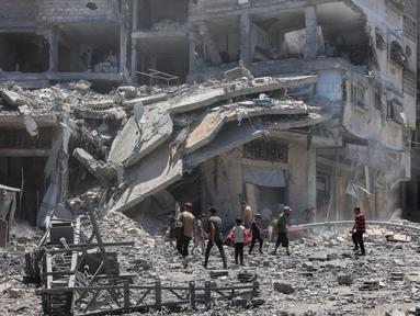 Warga Palestina mencari barang-barang yang dapat diselamatkan di reruntuhan bangunan yang hancur sehari sebelumnya dalam serangan Israel di lingkungan Al-Daraj, Kota Gaza pada 16 Juli 2025. (Omar AL-QATTAA/AFP)