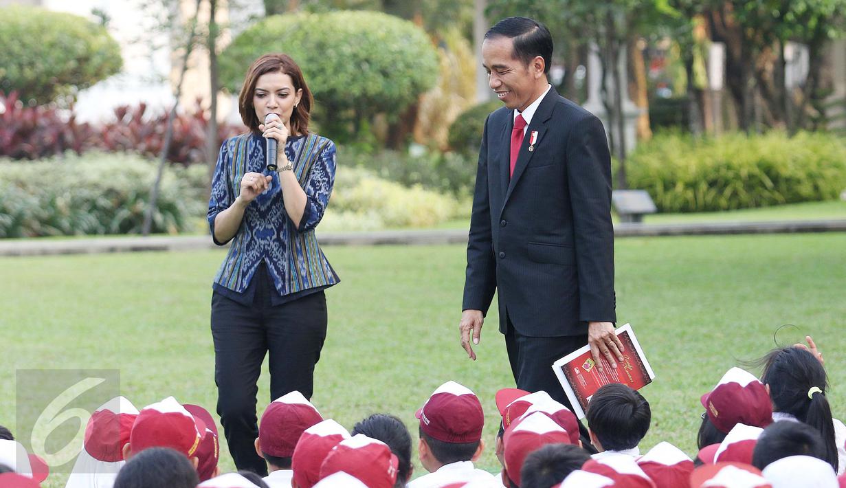 Presiden Joko Widodo didampingi Najwa Shihab saat mendongeng didepan puluhan pelajar di halaman tengah Istana, Jakarta, Rabu (17/5). (Liputan6.com/Angga Yuniar)