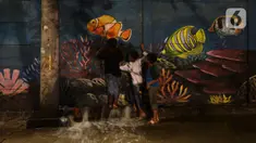 Anak-anak bermain air di kawasan Muara Baru dan Pantai Mutiara, Jakarta, Sabtu (6/6/2020). BMKG menyebutkan potensi rob di Perairan Utara Jawa disebabkan oleh kondisi pasang air laut yang cukup tinggi akibat fase bulan purnama dan potensi gelombang tinggi hingga 4 meter. (merdeka.com/Imam Buhori)