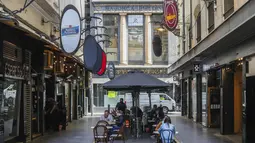 Pengunjung makan di luar ruangan di kawasan kafe pinggir jalan yang populer di Melbourne, Australia, Rabu (28/10/2020). Restoran-restoran dan kafe di Melbourne diizinkan untuk dibuka lagi setelah pemberlakuan lockdown yang ketat akibat Covid-19.  (AP Photo/Asanka Brendon Ratnayake)