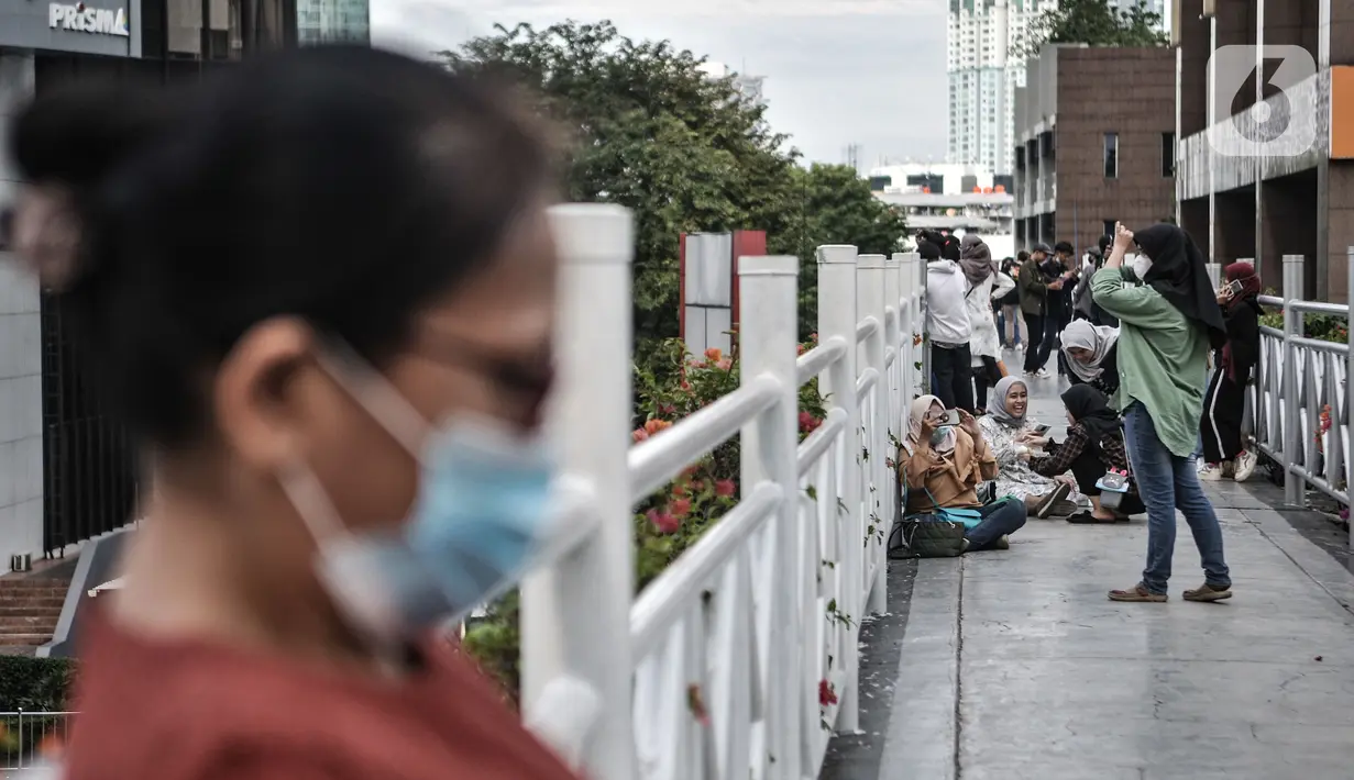 Warga berfoto di jembatan penyeberangan orang (JPO) tanpa atap di kawasan Sudirman, Jakarta, Minggu (4/4/2021). JPO tanpa atap masih menjadi wisata alternatif warga ibu kota dalam menghabiskan waktu akhir pekan untuk berfoto-foto dengan latar belakang gedung perkantoran (merdeka.com/Iqbal S Nugorho
