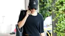 Dengan padu padan serba hitam, Lea Michele nggak ketinggalan sandal jepit dan sepatu olahraganya di tangan. (BROADIMAGE/REX/Shutterstock/HollywoodLife)