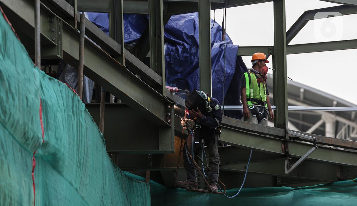 Pekerja menyelesaikan pembangunan halte Centrale Stichting Wederopbouw (CSW) di kawasan Kebayoran Baru, Jakarta, Selasa (8/6/2021). Halte yang akan menghubungkan antar moda transportasi yaitu Transjakarta dengan MRT tersebut mengambil desain Cakra Selaras Wahana. (Liputan6.com/Johan Tallo)