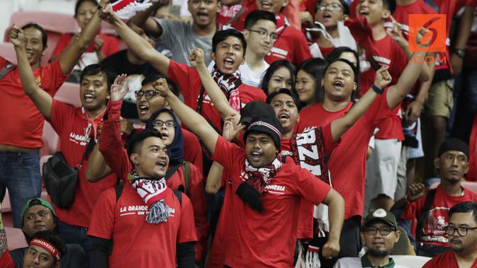 Suporter Timnas Indonesia memberikan dukungan saat melawan Singapura pada laga Piala AFF 2018 di Stadion Nasional, Singapura, Jumat (9/11). Singapura menang 1-0 atas Indonesia. (Bola.com/M. Iqbal Ichsan)