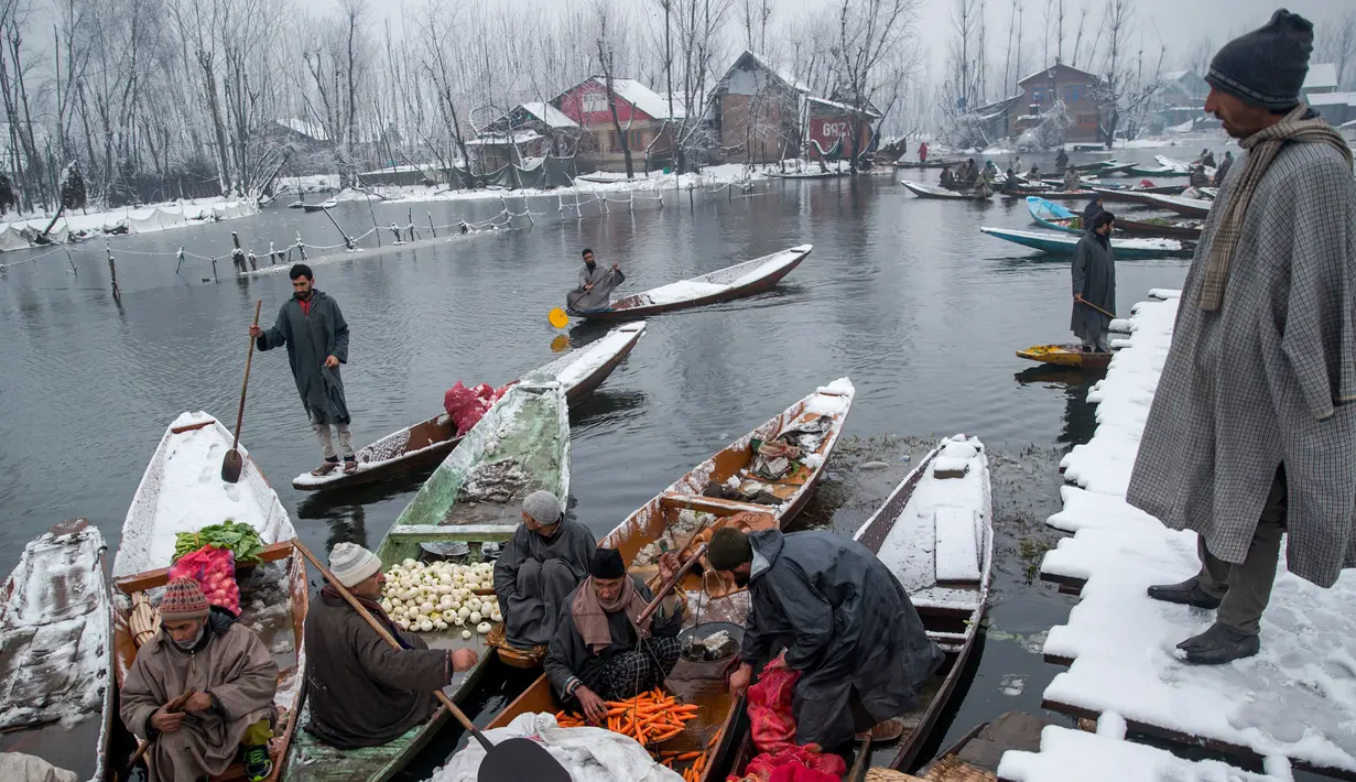 Pedagang menjual sayur dan buah-buahan di pasar terapung di danau Dal, Srinagar, Kashmir India, (25/1). berbagai jenis sayuran dapat dilihat di pasar ini yang kemudian dibawa ke Srinagar dan bandar-bandar sekitar Lembah Kashmir. (AP Photo/Dar Yasin)