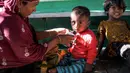 Para pengungsi menjalani serangkaian pemeriksaan kesehatan dan makanan di Desa Matang Pasi, Kabupaten Bireun, Provinsi Aceh pada tanggal 16 Oktober 2023, (AMANDA JUFRIAN/AFP)