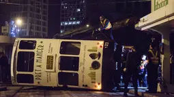 Regu penolong berusaha mengevakuasi trem double-decker yang terbalik di jalan utama di Hong Kong, Kamis (6/4). Belum jelas penyebab kecelakaan, namun kemungkinan akibat pengemudi gagal mengendalikan kendaraan tersebut. (ANTHONY WALLACE/AFP)