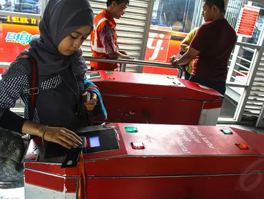 Calon penumpang TransJakarta melakukan tapping (menempelkan) e-ticketing di koridor I Harmoni, Jakarta, (23/10/14). (Liputan6.com/Faizal Fanani)