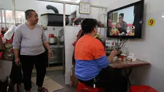 Warga menonton berita CCTV pagi di TV kunjungan pemimpin Korea Utara Kim Jong Un ke China, di sebuah restoran di daerah Jiexi di provinsi Guangdong China selatan, (28/3). Ini merupakan lawatan pertama Kim sejak menjabat pada 2011. (AP Photo/Andy Wong)