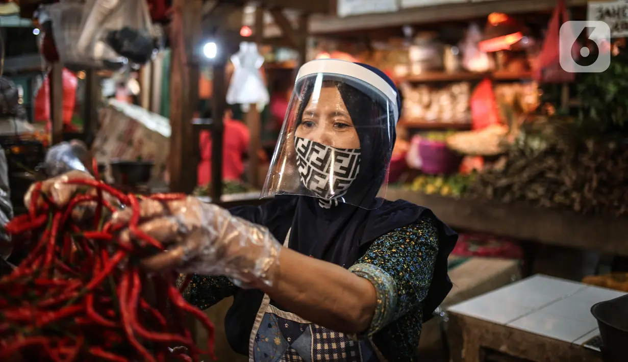 Salah satu pedagang menggunakan face shield dan sarung tangan saat melayani pembeli di Pasar Senen, Jakarta, Senin (1/6/2020). Kementerian Perdagangan menyiapkan pedoman bagi penyelenggara kegiatan perdagangan untuk diterapkan pada saat kenormalan baru (new normal). (Liputan6.com/Faizal Fanani)