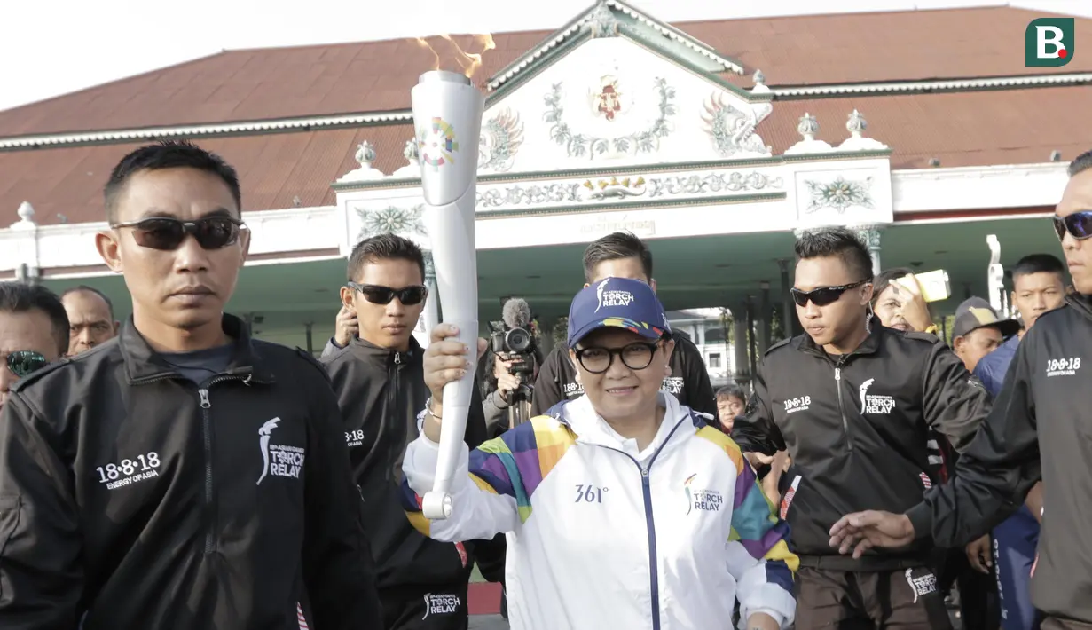 Menteri Luar Negeri, Retno Marsudi, menjadi pelari pertama kirab obor Asian Games 2018 di Pagelaran Keraton Yogyakarta, Kamis (19/7/2018). Total jarak kirab Obor di Yogya ini sepanjang 11,5 kilometer. (Bola.com/M Iqbal Ichsan)
