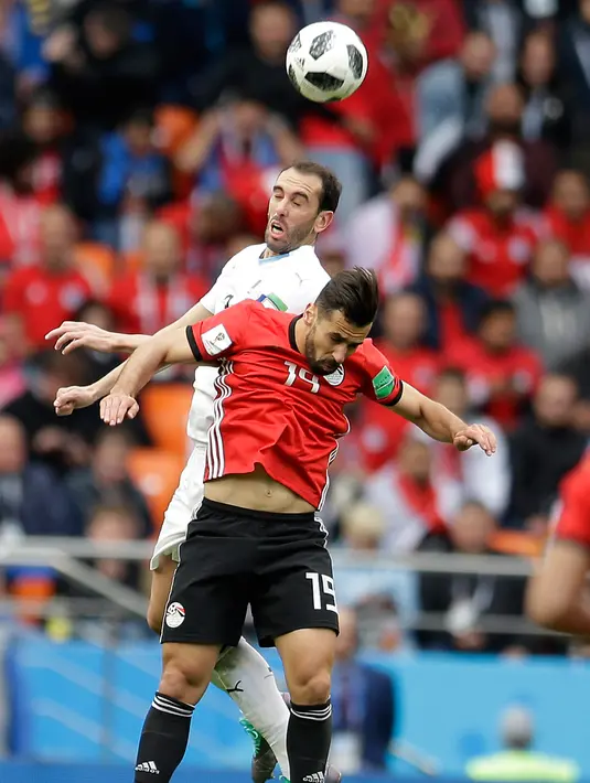 Bek Uruguay Diego Godin berebut bola udara dengan pemain Mesir Mahmoud Hamdy saat bertanding pada grup A Piala Dunia 2018 di Yekaterinburg Arena, Rusia, (15/6). Uruguay menang dramatis atas Mesir 1-0. (AP Photo / Natacha Pisarenko)
