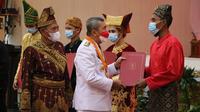 Gubernur Riau Syamsuar bersama Kepala Kanwil Kemenkumham Riau Mhd Jahari Sitepu memberikan surat remisi kepada narapidana. (Liputan6.com/M Syukur)