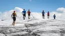 Sejumlah peserta berlari melintas di Glacier Tsanfleuron saat mengikuti Glacier 3000 Run and Marathon di Les Diablerets, Swiss (5/8). Peserta lomba lari harus melewati lintasan sepanjang 42km dengan ketinggian 2.807 meter. (AFP Photo/ Fabrice Coffrini)