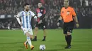 Lionel Messi (kiri) saat bertanding memakai seragam Timnas Argentina dalam acara pertandingan perpisahan Maxi Rodriguez sebagai pesepak bola profesional yang diselenggarakan di Marcelo Bielsa Stadium, Argentina, Minggu (25/6/2023). (AFP/Stringer)