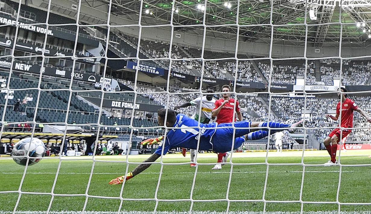 Pemain Borussia Moenchengladbach, Marcus Thuram, mencetak gol ke gawang Union Berlin pada laga Bundesliga di Stadion Borussia-Park, Minggu (31/5/2020). Moenchengladbach menang 4-1 atas Union Berlin. (AP/Martin Meissner)