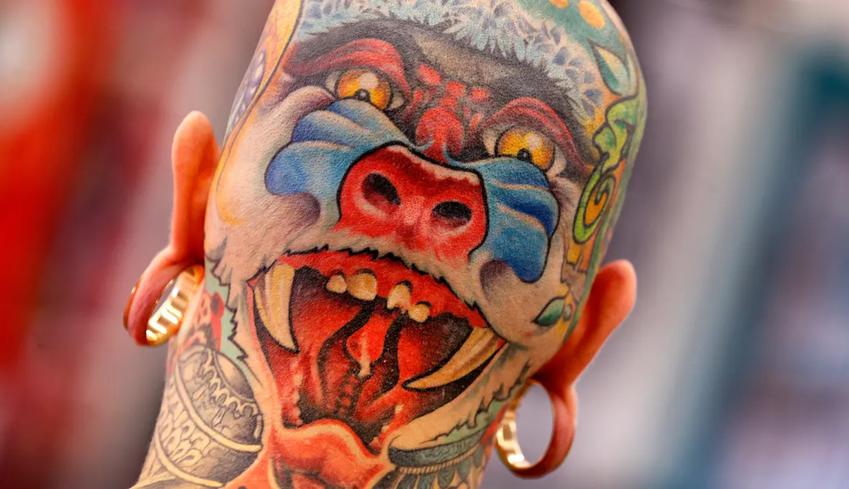 Seorang pria asal Belanda menunjukkan tato di bagian belakang kepalanya pada hari pertama Konvensi Tattoo Frankfurt di Frankfurt, Jerman, Jumat, 21 April 2017. Acara ini diikuti oleh ratusan seniman tato dari berbagai negara. (AP Photo / Michael Probst)