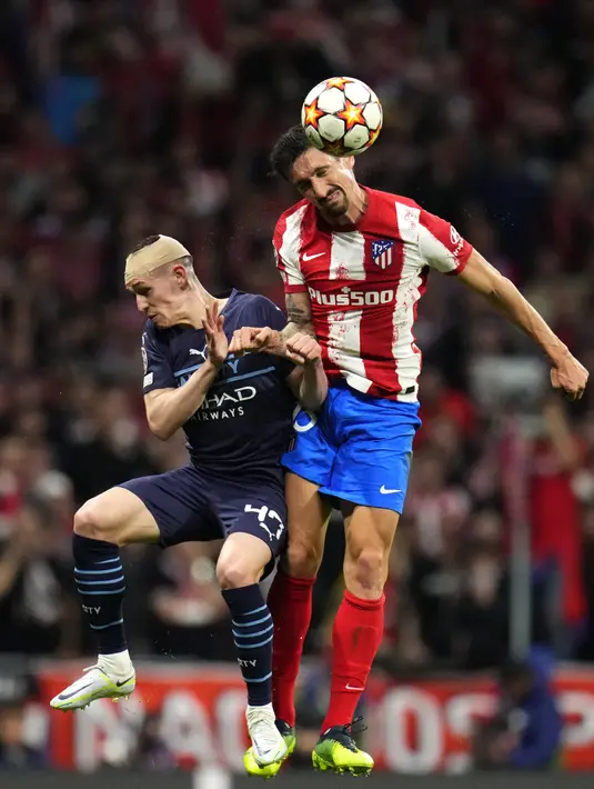 Pemain Manchester City Phil Foden (kiri) berebut bola dengan pemain Atletico Madrid Stefan Savic pada pertandingan sepak bola leg kedua perempat final Liga Champions di Stadion Wanda Metropolitano, Madrid, Spanyol, 13 April 2022. Pertandingan berakhir imbang 0-0. (AP Photo/Manu Fernandez)