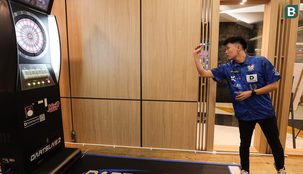 Dartslive Support Player asal Singapura Phuay Wei mencoba salah satu alat di acara peluncuran Darts Station di lantai F7 FX Sudirman, Senayan, Jakarta pada Sabtu (15/11/2025). (Bola.com/Abdul Aziz)