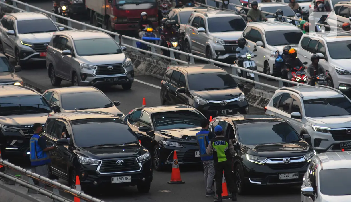 Petugas Jasa Marga melakukan pelayanan transaksi  kartu masuk tol dalam kota kepada pengendara roda empat di Jakarta, Selasa (9/5/2023). (merdeka.com/Imam Buhori)