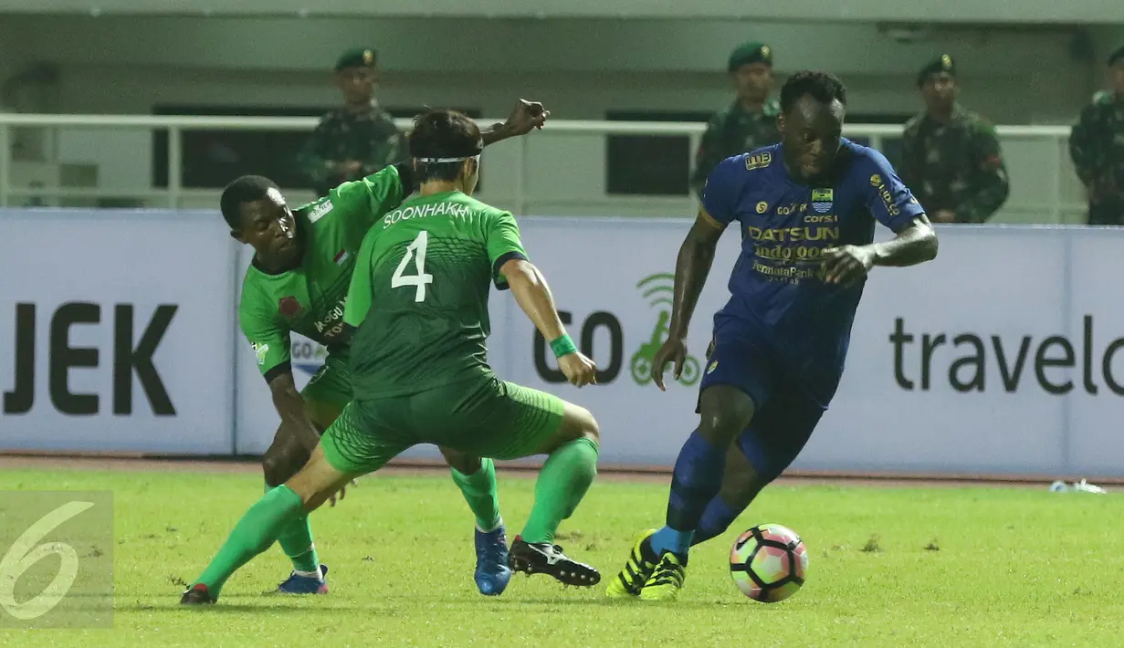 Gelandang Persib, Michael Essien (kanan) melewati dua pemain PS TNI pada lanjutan Liga 1 di Stadion Pakansari, Kab Bogor, Sabtu (22/4). PS TNI bermain imbang Persib 2-2. (Liputan6.com/Helmi Fithriansyah)