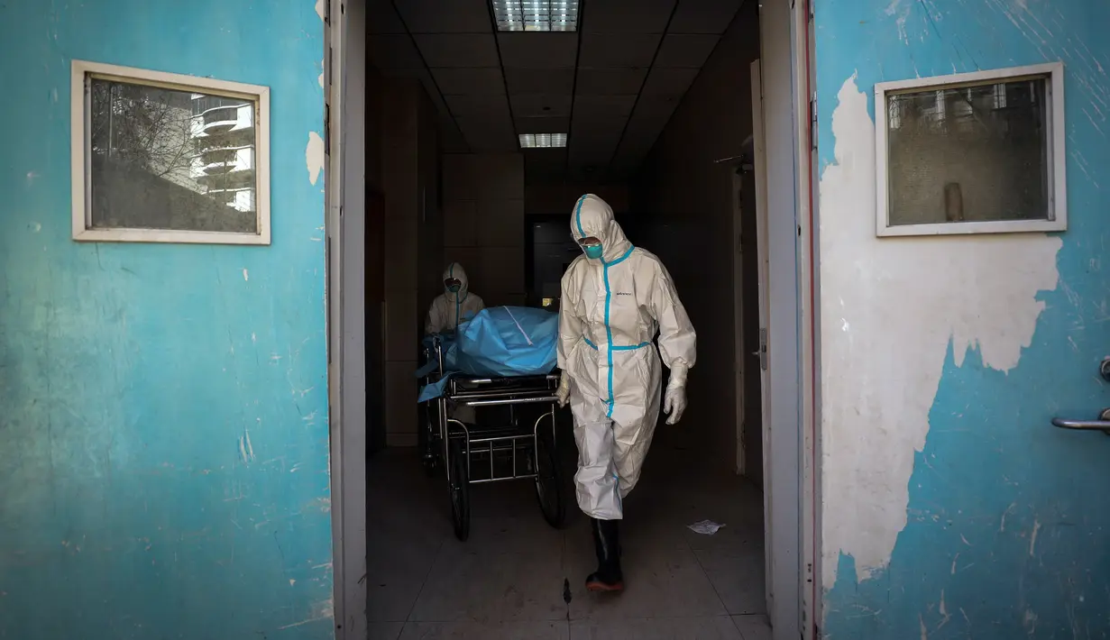 Pekerja medis memindahkan pasien virus corona atau COVID-19 yang meninggal di sebuah rumah sakit di Wuhan, Provinsi Hubei, China, Minggu (16/2/2020). Virus corona telah menginfeksi puluhan ribu orang di China, tak terkecuali pekerja medis. (Chinatopix via AP)