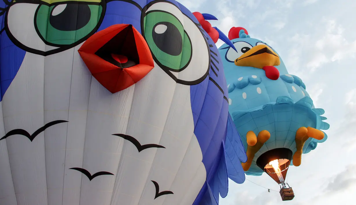 Balon udara berbentuk kepala burung dan ayam terbang selama Festival Balon Udara Internasional XVIII di  Leon, negara bagian Guanajuato, Meksiko pada 16 November 2019. Tak hanya balon udara biasa, banyak yang memiliki bentuk, serta warna unik menyemarakkan langit Kota Leon. (MARIO ARMAS / AFP)
