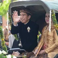 Dengan Kereta Kencana, rombongan keluarga besar Presiden Joko Widodo saat itu hendak menuju ke lokasi pernikahan Kahiyang dan Bobby di Graha Saba Buana. Lambaian tangan dan senyuman terus diberikan Jokowi. (Adrian Putra/Bintang.com)