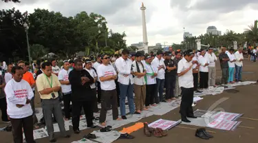 Massa dari Aliansi TKI Menggugat melakukan aksi unjuk rasa dengan cara salat di depan Istana Negara, Jakarta, Selasa (7/4/2015). Mereka menuntut Presiden Jokowi mencabut moratorium larangan pengiriman TKI ke Timur Tengah. (Liputan6.com/Helmi Afandi)