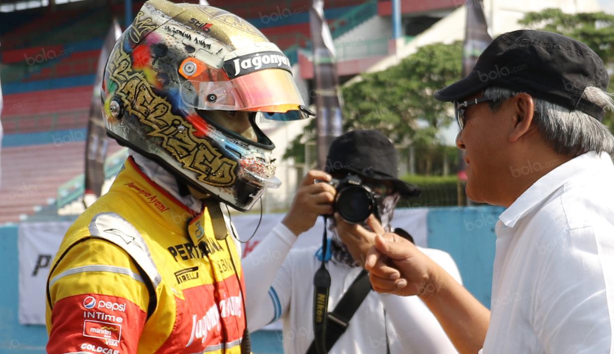 Sean Gelael saat berbincang dengan Ayahnya Ricardo Gelael sebelum memacu Lamborghini pada ajang Taxi Ride di Sirkut Sentul, Selasa (2/8/2016).  (Bola.com/Nicklas Hanoatubun)