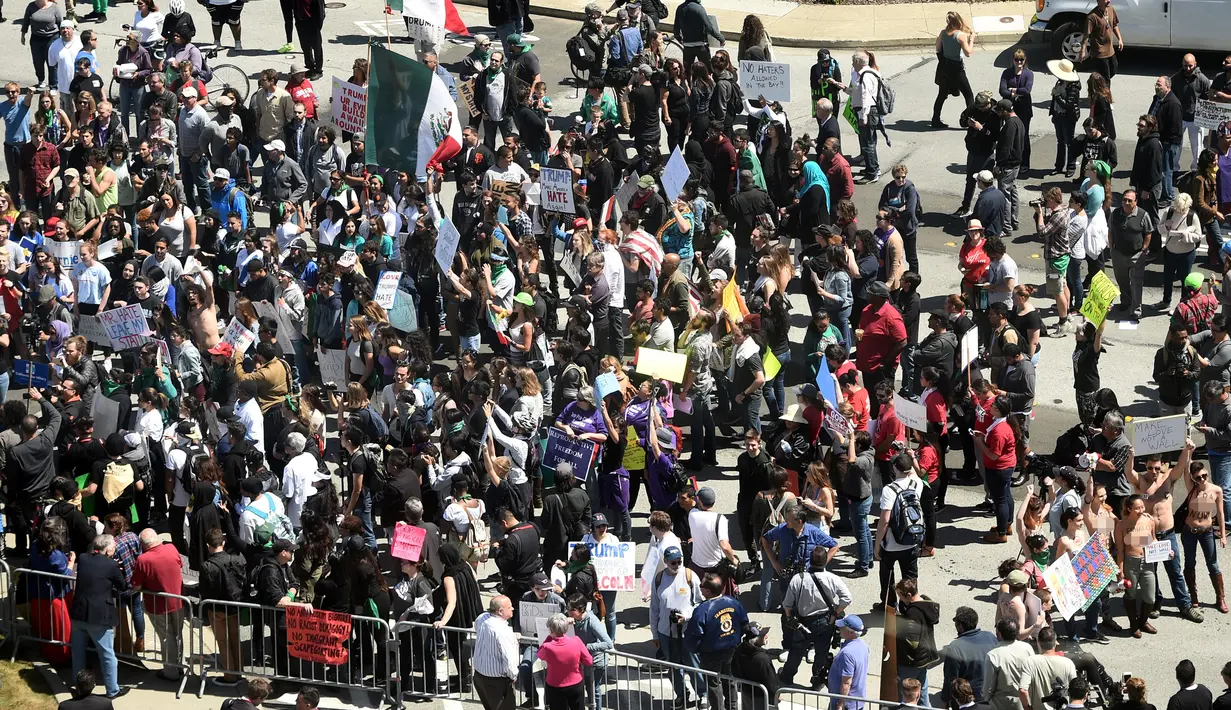 Sejumlah wanita bertelanjang dada sambil membawa poster tuntutan saat menggelar demo menolak Donald Trump di Burlingame, California (29/4). Para wanita ini menolak Donald Trump menjadi Presiden Amerika Serikat. (REUTERS/Noah Berger)